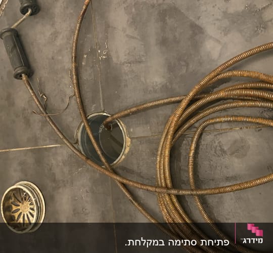 נחשול אינסטלציה על רצפת אריחים אפורה